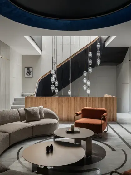 The first-floor lounge in The House of Dancing Screens is a spacious area connecting the son's and daughter's bedrooms. The curved sofa and circular floor inlay echo the home's fluid design language.