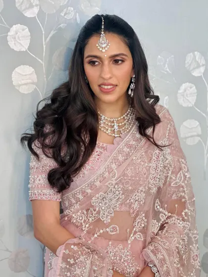 A vision in pink. This beautiful Abu Jani Sandeep Khosla saree with intricate white embroidery is the definition of soft, feminine elegance. The look is completed with a stunning maang tikka and pearl necklace.