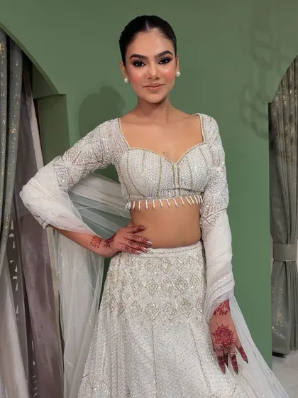 A full-length view of the white chikankari lehenga look. The makeup is kept soft and clean to let the beautiful outfit shine.