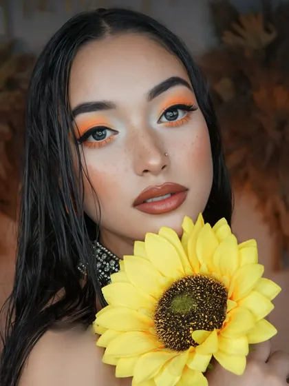 Inspired by sunflowers, this look features a bold orange eyeshadow and faux freckles for a fresh, artistic vibe.