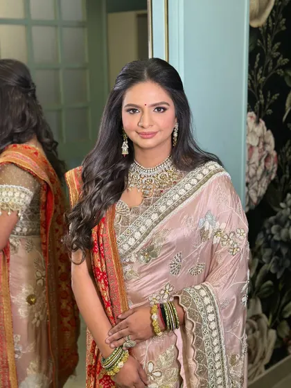 The final look of the client with her soft half-updo, looking elegant in a beautiful saree.