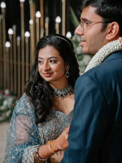 A candid moment from the reception. Her makeup is subtle and elegant, with a soft shimmer on the eyes that catches the light beautifully.