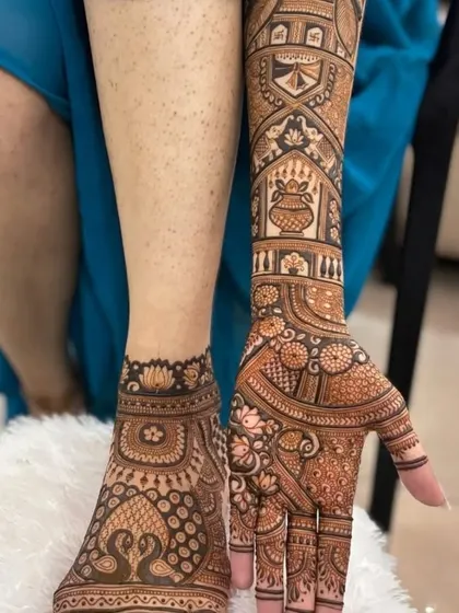 This image shows how the hand and foot mehandi can be designed to complement each other, with similar peacock and floral elements.