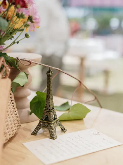 A miniature Eiffel Tower and a handwritten note add a personal, romantic touch to the table decor.