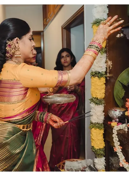 Akanksha performing rituals during her engagement ceremony, giving a glimpse of the side view of her custom blouse.