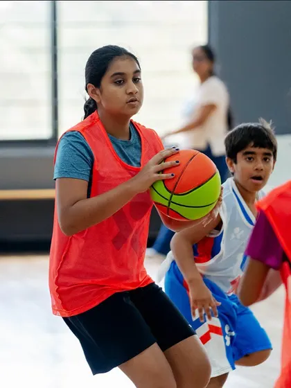 A young player focused on protecting the ball during a scrimmage.