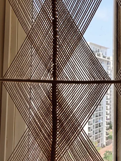 A close-up of the geometric partition, showing the precision of the straight lines created with macrame knots.