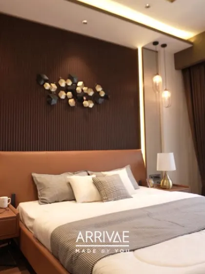 This bedroom has a warm and masculine feel, with a dark wood fluted accent wall, a leatherette bed, and metallic wall art. The hanging pendant lights add a modern touch.