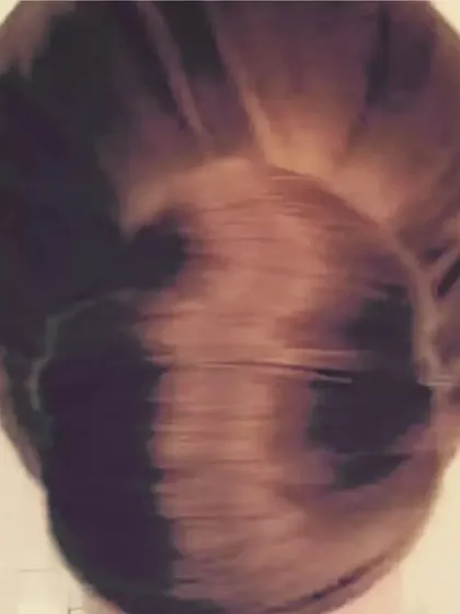 This is a classic, smooth chignon bun. It's a versatile and clean hairstyle that is perfect for any formal occasion, providing a polished foundation for adding flowers or other hair accessories.