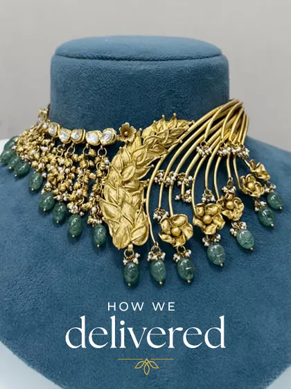 The final delivered product of a unique statement necklace. This piece was crafted from various old gold elements, including a leafy motif and floral pieces, combined with kundan and green beads.