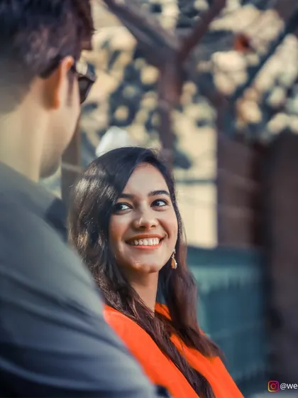 An over-the-shoulder shot that captures a genuine, radiant smile, making for a perfect candid pre-wedding portrait.