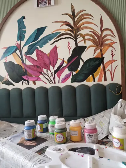 A shot of my paint palette and supplies in front of the partially completed tropical mural, giving a glimpse into the colors used.