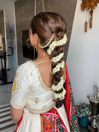 A stunning shot of Mansi's traditional braided hairstyle, adorned with fresh flowers. A perfect example of classic bridal hair artistry.