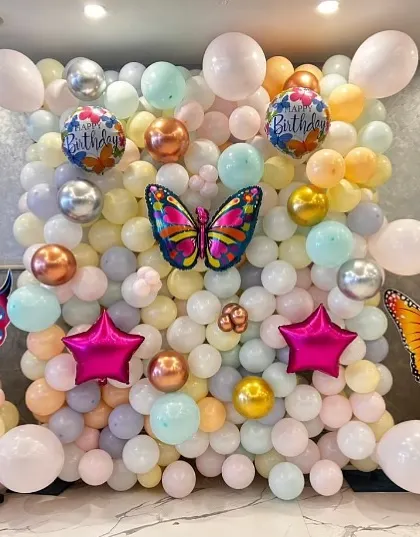 A beautiful butterfly-themed balloon wall in pastel colors. This makes for a perfect photo backdrop for a birthday party.
