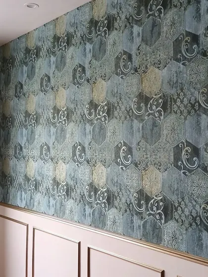 A real client project. This stunning accent wall features a hexagonal-patterned wallpaper in shades of blue and gold, adding artistic flair and a unique focal point to the room.