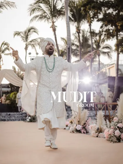 A joyful portrait of the groom at his beach wedding.