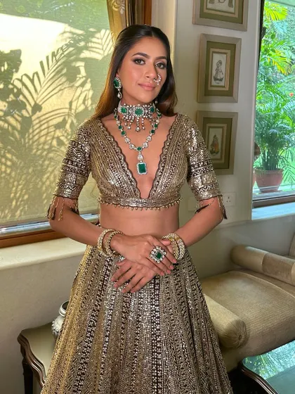 The full look, showcasing the stunning black and gold lehenga. The makeup is designed to be dramatic and unforgettable, perfect for a grand event.