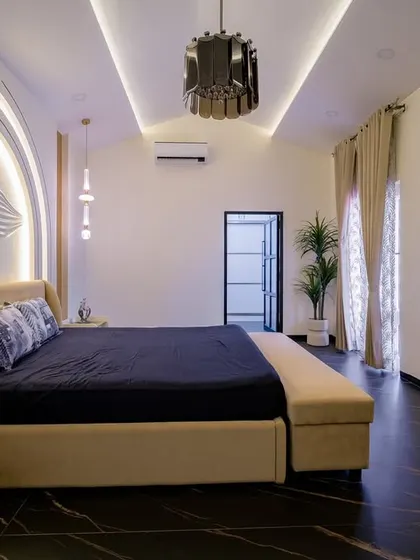 Simple, stunning, and perfectly designed for modern living. This bedroom features a unique backlit headboard with a floral relief, dark marble floors, and a sleek pendant light, creating a luxurious and artistic atmosphere.