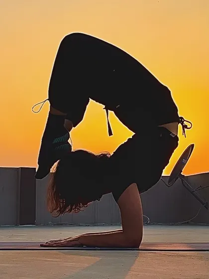 This is a moment of pure focus and strength, holding a scorpion pose against the setting sun. Achieving advanced postures like this is a journey of patience and consistent practice, something we work on every day.