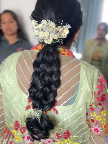 A simple yet elegant South Indian braid, finished with a cluster of fresh baby's breath flowers. This is a versatile style you'll create for many clients.