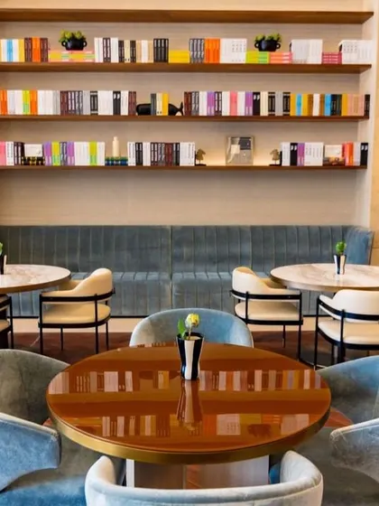 A closer look at the banquette seating along the wall of the Elevate Clubhouse. The built-in shelving and warm sconce lighting create a cozy, library-like atmosphere, making it an ideal spot for dining or reading.