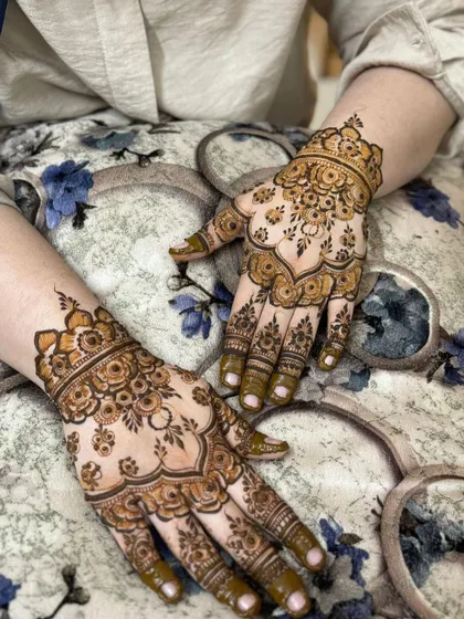 A delicate, scalloped henna design on the back of the hands, perfect for a party.