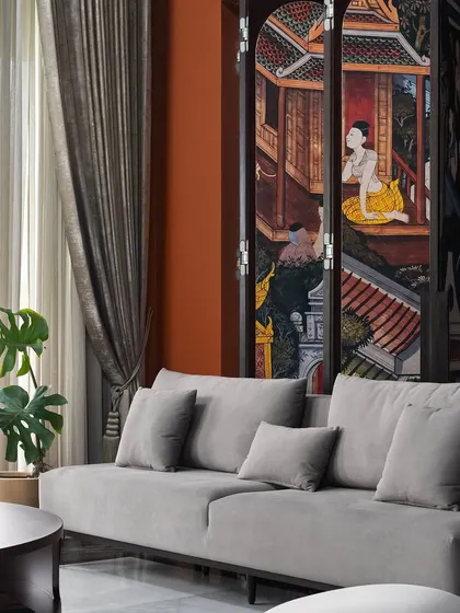 This detail shot highlights the beautiful hand-painted folding screen, which tells a story and adds a layer of cultural depth. It's paired with a minimalist sofa to let the artwork truly stand out.