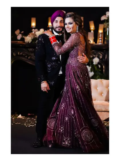 A classic, happy portrait of the couple at their reception. Their smiles and embrace capture the joy and love they share, framed by elegant decor.