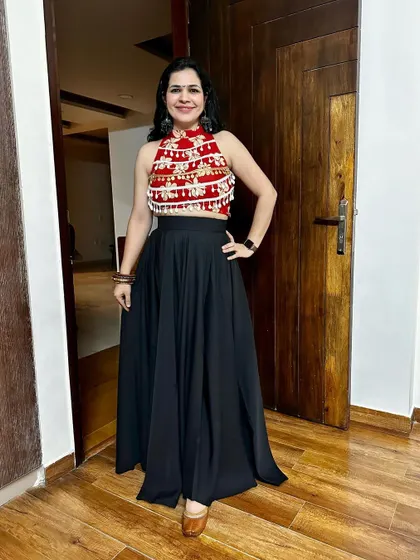 This red and black top with a flared black skirt is a fun and comfortable outfit for Navratri or any dance-filled event. It's a great fusion look that's both stylish and easy to move in.