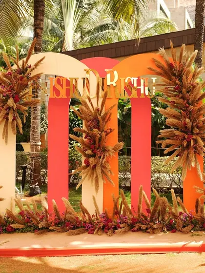 A personalized welcome sign for the Mehndi, featuring modern arches in warm tones and decorated with dried grasses and florals, perfectly matching the Souk Bazaar theme.