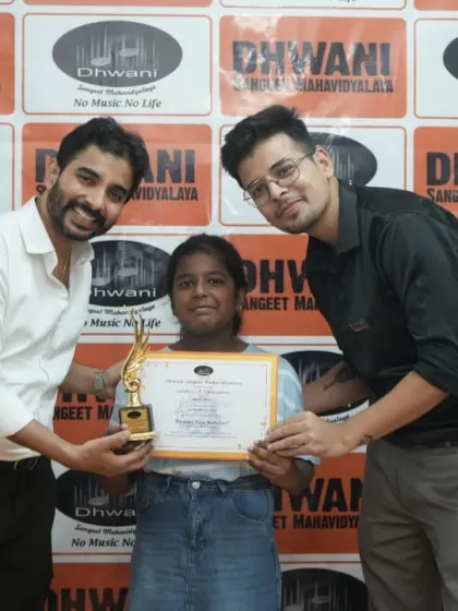Two teachers present an award to their student.