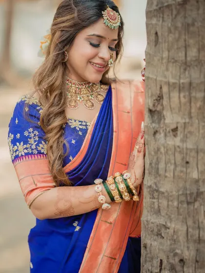 A sweet and simple bridal portrait, with the bride leaning against a tree, her smile radiating happiness.