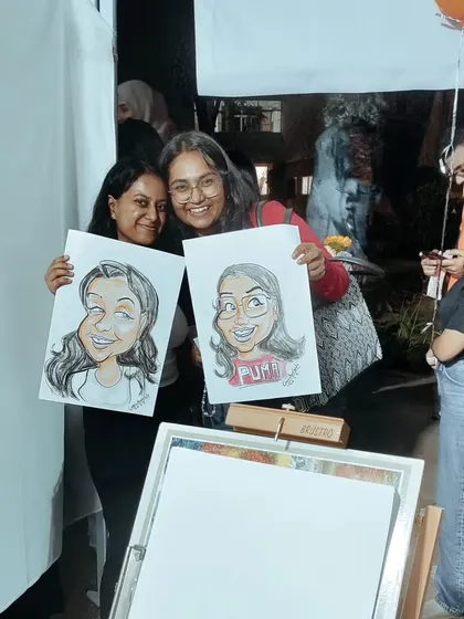 Friends having a great time at a carnival event. They were so excited to get their caricatures done together, and each left with a personal, funny portrait to remember the day.