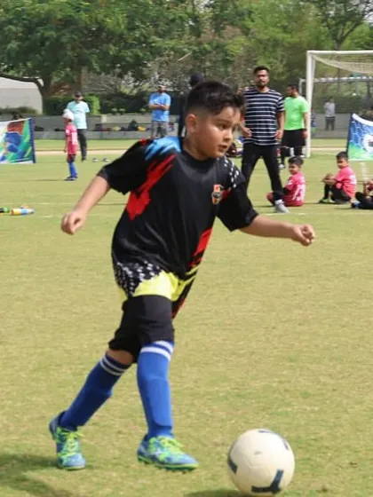 A player controls the ball, looking for a pass during a competitive game.