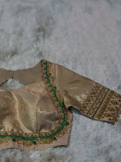 A different angle of the beige blouse, focusing on the simple yet elegant sleeve embroidery.
