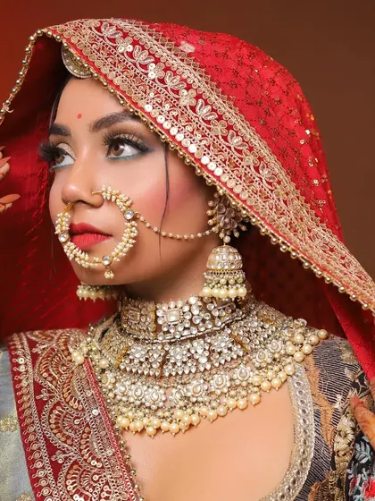 A beautiful profile shot of the bridal look, highlighting the heavy jewelry, the dramatic eye makeup, and the perfectly draped dupatta.