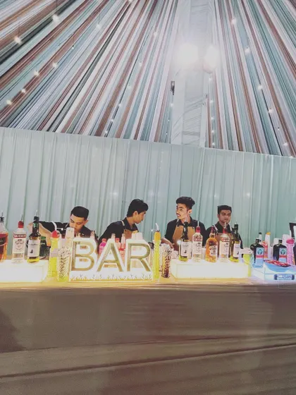 Our team of professional bartenders ready for a large wedding reception. The well-lit and fully stocked bar is designed for efficiency and elegance, ensuring quick service for all your guests.