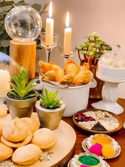 A festive table setup for a Holi party, featuring my homemade gujiyas and other snacks, surrounded by elegant candles and decor.