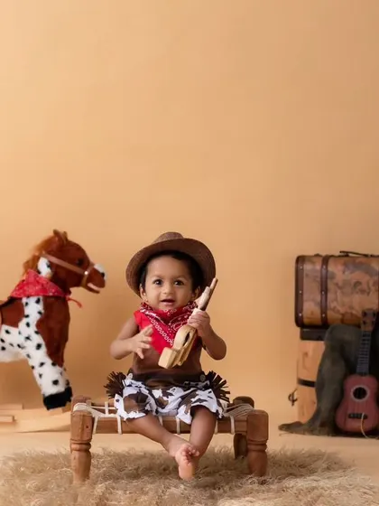 A full shot of the cowboy setup, showing all the rustic elements that make this theme a favorite. From the hat to the rocking horse, every detail is taken care of.