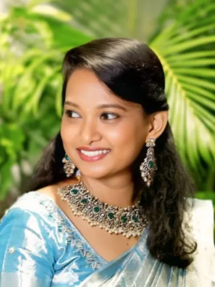 A happy client looking lovely in a silver-finish necklace set with green stones. This is a great example of a statement piece that can be rented for parties or smaller family functions.