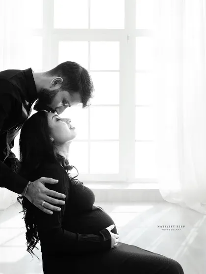 An incredibly tender and intimate black and white portrait. The soft window light and the couple's gentle embrace create a truly emotional image.
