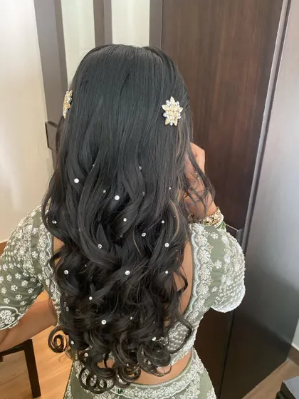 A half-up style with soft curls, accessorized with scattered pearls and two star-shaped crystal clips. This is a simple yet glamorous look for any party or festive occasion.