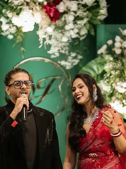 The couple enjoying their celebration against the elegant green and white backdrop. The contrast of their vibrant attire with the sophisticated decor highlights how the design serves to make the clients the center of attention.