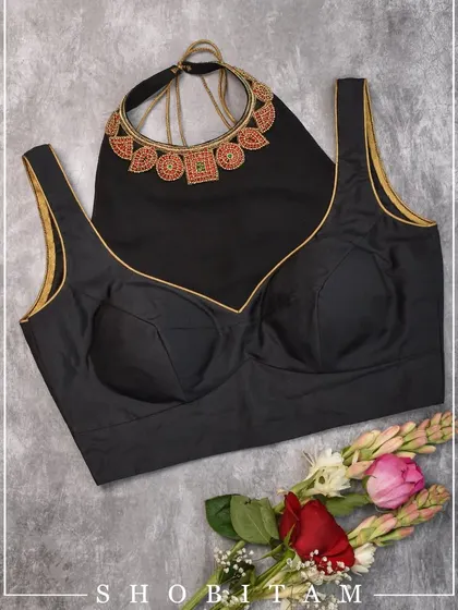 A flat-lay of a modern black blouse paired with a matching beaded choker, showing how you can style a complete look.