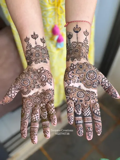 An intricate party mehndi design that combines bold floral elements with delicate checkered patterns.