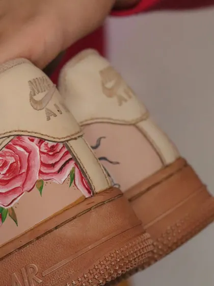 A close-up of the heel of the tea-dyed AF1s, showing the delicate rose paintings. The tea provides a softer, lighter vintage tone compared to coffee.