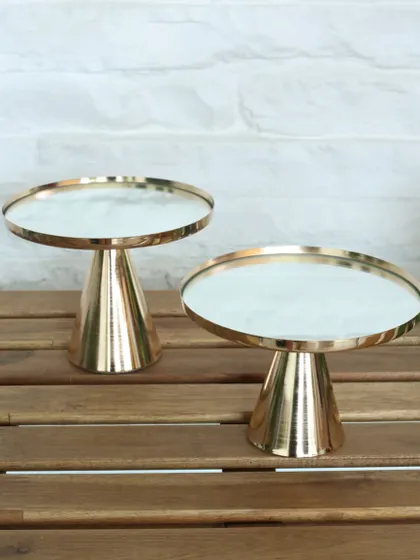 The marble-topped Vesper stand, featuring a white marble surface and a polished gold base. This piece combines classic materials with a modern silhouette for a truly timeless look.