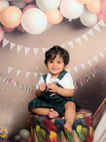 A cute baby boy enjoying his photoshoot with a fun, teepee-themed setup in the studio.