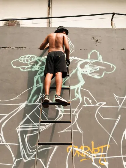 The process of going big. Up on a ladder, sketching out the initial lines for the mural. Every big piece starts with a simple outline before the colors and details come in.
