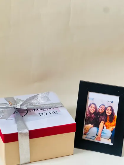 The exterior of a 'Bride to be' gift box, elegantly designed and tied with a silver ribbon. I can include a cherished photo to make the gift even more personal.